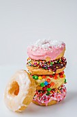 Ein Stapel bunt verzierte Donuts vor weißem Hintergrund