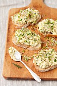 Slices of bread topped with egg salad and bean sprouts