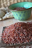Red rice on a wooden coconut dish (Asia)