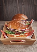 Two homemade cheeseburgers on a wooden tray