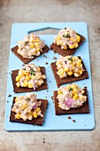 Pumpernickel bread with tuna paste, sweetcorn and red onions