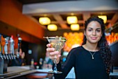 A young woman serving a cocktail