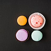 Vier Macarons auf schwarzem Grund