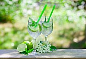 Two glasses of Hugo with limes, mint and elderflower syrup