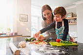 Mutter und Sohn bereiten Pizza in der Küche zu