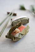 Salmon sushi with ginger strips wrapped in a leaf