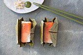 Salmon sushi with ginger strips and wasabi wrapped in a leaf