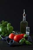 An arrangement of tomatoes with basil and olive oil