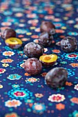 Damsons on a blue, floral patterned tablecloth