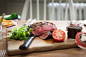 Grilled beef steak with chutney on a wooden chopping board