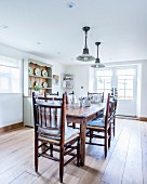 Wooden dining table and chairs in rustic dining room with wooden floor