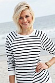 Blonde Frau in schwarz-weiss gestreiftem Langarmshirt am Strand