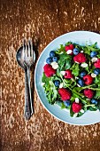 Green salad with rocket, berries and flaked almonds