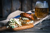 A rustic fish burger with coleslaw and beer