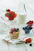 A healthy breakfast: muesli with fresh fruit and milk, strawberries, raspberries, blueberries on a wooden table