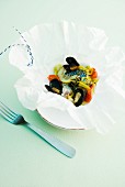 Fish and mussels with leek and tomatoes in parchment paper