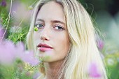 A portrait of a young woman in a field of flowers