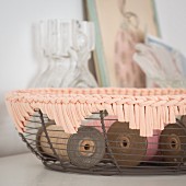Spools of thread in a wire basket with a crocheted trim
