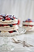Hazelnut pavlova with fresh berries, cream and berry sauce