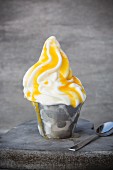 Frozen yoghurt in a metal cup with passion fruit purée