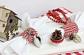 Festive table decoration with nesting box, napkin rings, garland of stars & pine cones