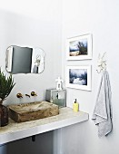Waschtisch mit Waschbecken aus Beton, an Wand Vintage Spiegel und gerahmte Fotos