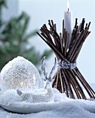 Christmas arrangement of glass bauble, reindeer ornament and candle holder hand-made from bundled twigs