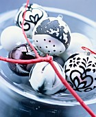 Hand-decorated Christmas baubles on glass plate