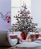 Christmas tree decorated with artificial snow and red baubles