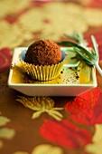 A chocolate truffle with rosemary (close-up)