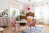 Antique wooden bed and children's table and chairs in girl's bedroom