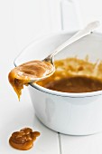 Caramel sauce on a spoon and in a saucepan