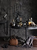 Gothic Stillleben mit mehrarmigem Kerzenhalter auf einem Tisch vor antrazithfarbenem Hintergrund