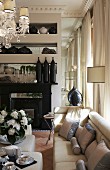 Elegant living room with stucco ceiling, collection of vases on mirrored shelves above fireplace and gas stove