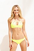 Junge blonde Frau in gelbem Bikini