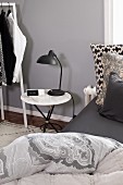 Marble-topped bedside table in bedroom in shades of grey