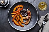 Veal sausage with fried pumpkin wedges and fig chutney
