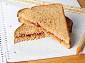 Sandwich mit Erdnussbutter & Marmelade auf Schreibblock