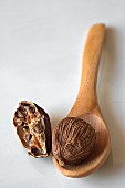 Black cardamom on a wooden spoon and next to it