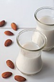 Two glasses of almond milk with whole almonds