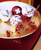 Festive arrangement of berries and baubles in gold dish