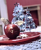 Weihnachtsapfel verziert mit Engelsflügeln als Namensschild