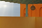 Hängeleuchte in orientalischem Stil an Pergola Kassettendecke, im Hintergrund orangefarbenes Haus