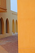 Arched windows and doorways and yellow walls in Oriental courtyard