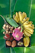 A bowl of tropical fruit on banana leaves