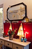 Wooden Christmas trees on console table against red wainscoting
