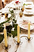 Filigraner Kerzenhalter aus Metall mit Blütenmotiv auf gedecktem Tisch