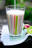 A glass of soya milk with a straw