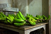 Grüne Bananen auf Holztisch auf einem Markt in Bali