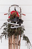 Vintage sledge decorated with ice skates, conifer branches and pine cones